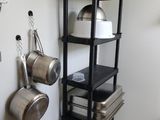 une étagère avec des casseroles et des poêles dans une cuisine