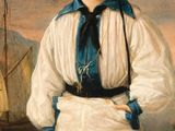 portrait of a boy in a straw hat and white pants standing in front of a boat