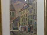 tableau encadré représentant une scène de rue avec des bâtiments et une tour horloge
