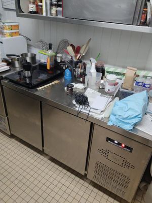 une cuisine avec beaucoup de désordre sur le comptoir