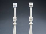 pair of white candlesticks on a grey background