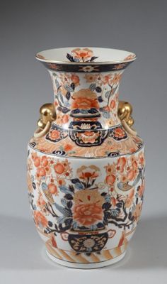 a vase with a floral design on it sitting on a table
