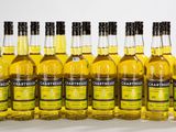 six bouteilles de bière sont alignées les unes à côté des autres sur une surface blanche