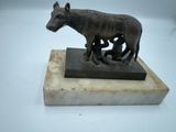 a small statue of a donkey on a marble base