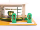 a small model of a gas station with two green gas pumps