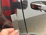 a person holding a ruler in front of a car door