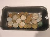 a lot of coins in a black bowl on a table