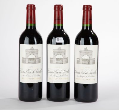 trois bouteilles de vin rouge posées côte à côte sur une table