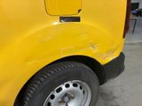 a close up of a yellow van parked in a parking lot