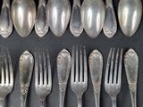 a lot of silver spoons and forks on the table
