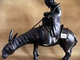 statue of a man riding a horse with a hat on his head