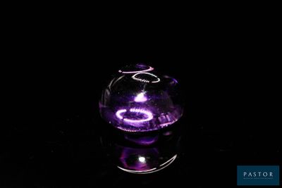 a glass vase with a purple light inside of it