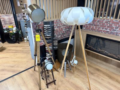 une lampe posée sur un trépied à côté d'une cheminée