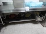 un plan de travail en acier inoxydable sur lequel sont posés des casseroles et des poêles
