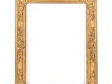 un cadre photo doré sur un mur blanc avec un fond blanc