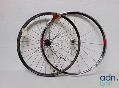 une paire de roues de vélo noires et blanches posées sur une surface blanche
