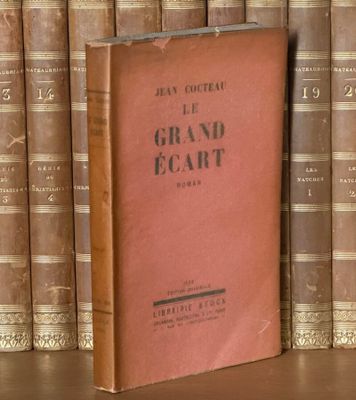 un livre posé sur une étagère, devant une pile de livres