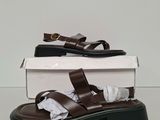 the brown sandals are sitting on top of a white box