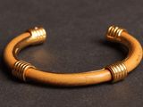 a close up of a gold bracelet on a black surface