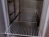 an open refrigerator with a metal rack in it