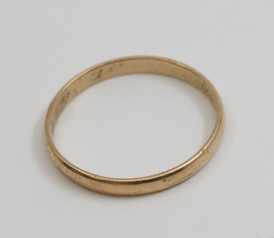 gros plan d'une bague en or sur une surface blanche