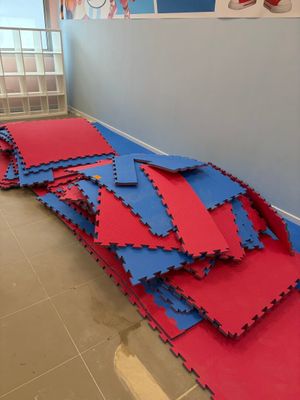 un tas de tapis rouges et bleus posés par terre dans une pièce
