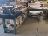 un grand établi au milieu d'une pièce, sur lequel sont posées de nombreuses boîtes