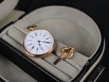 une montre dans un étui contenant une clé