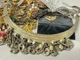 a pile of jewelry on a table next to a mirror