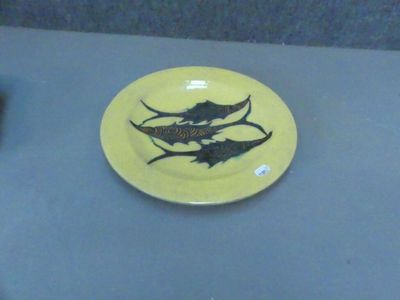 une assiette jaune sur laquelle est posé un poisson, posée sur une table