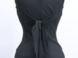 the back of a black dress with a tie around the waist