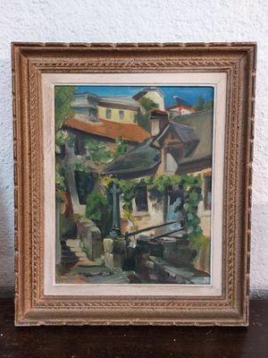 an oil painting of a street scene in a frame on a table