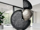 une sculpture noire et argentée posée sur une table dans une pièce