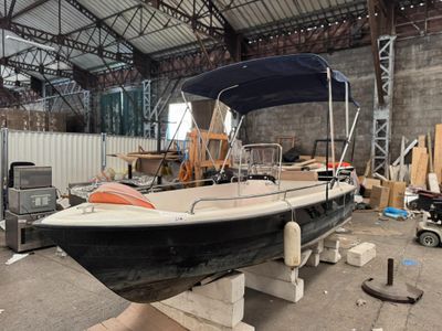 un bateau noir et blanc dans un bâtiment doté d'un auvent bleu