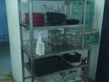 a metal shelf with dishes on it in a kitchen