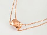 gros plan d'un collier en or sur une surface blanche