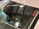 a broken windshield of a car with a no smoking sign on it