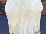carved glass figurine of a woman in a white dress on a stand