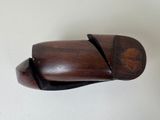 a wooden shoe that is on a white surface