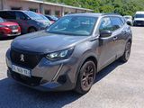 La voiture grise est garée sur un parking avec d'autres voitures.