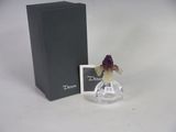 a small glass vase with a flower in it next to a box