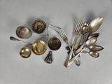 a lot of silverware on a table with spoons and spoons