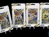 three packs of pokemon trading cards are displayed on a black background