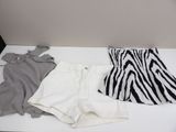 zebra print top, white shorts, and black and white top on a white table