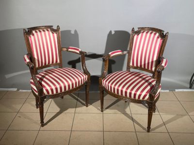 two red and white striped chairs sitting next to each other on a tiled floor