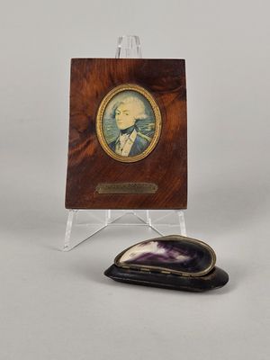 une image représentant la photo d'un homme en costume à côté d'une plaque en bois