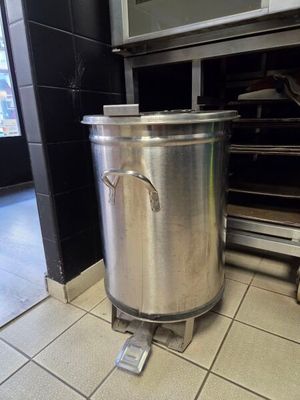 a large pot that is sitting on the floor in the kitchen