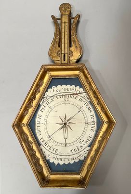 une vieille horloge accrochée au mur, dans un cadre doré