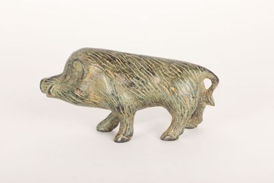 figurine en laiton représentant un cochon sur fond blanc
