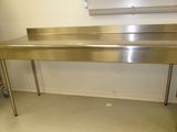 une table en acier inoxydable avec un évier dans une cuisine